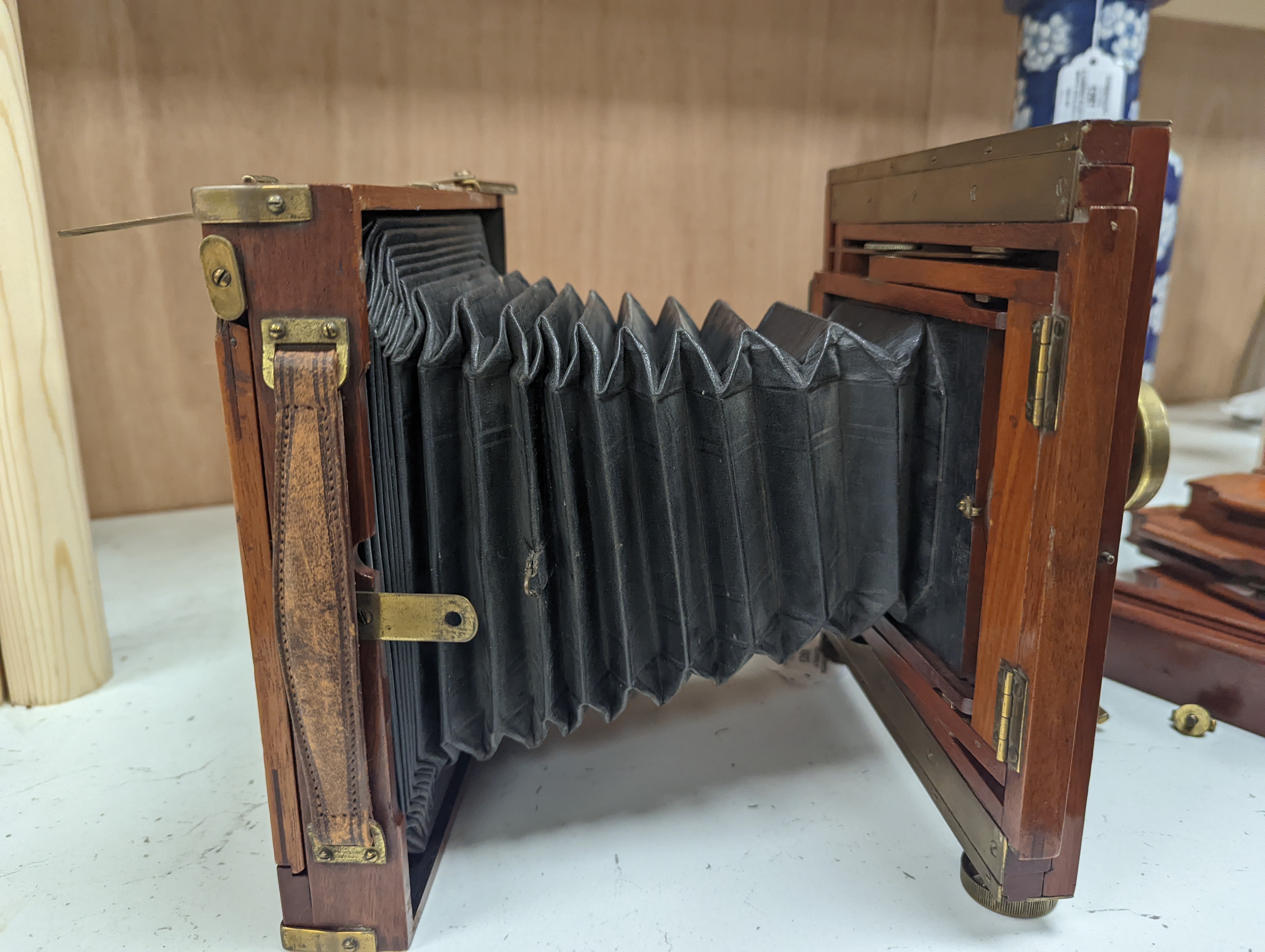 A Thornton Pickard mahogany and brass plate camera, three plates and a stand, 20cm sq.